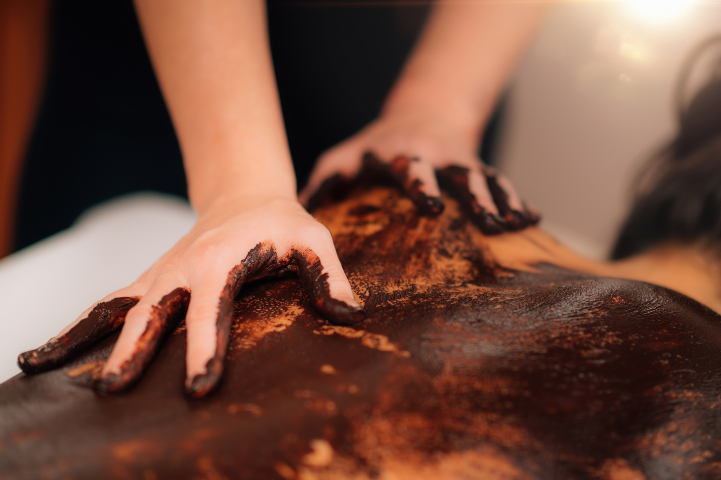 Chocolate Massage Treatment. Woman Having Back Chocolate Massage in Beauty Salon.